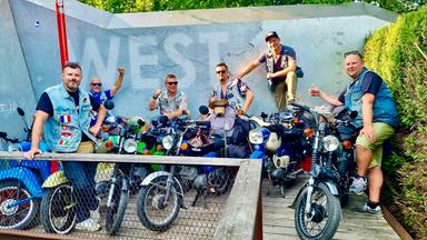 Sechs Männer, im Vordergrund stehen Simson-Mopeds.