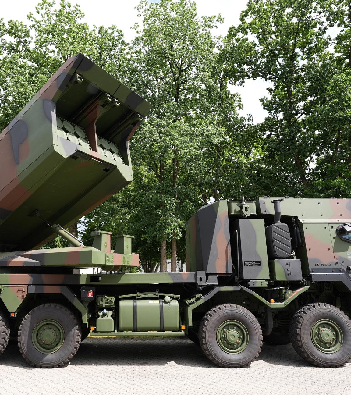 Ein Mehrfachraketenwerfer auf einem LKW in Camoufalge steht auf einem Parkplatz.