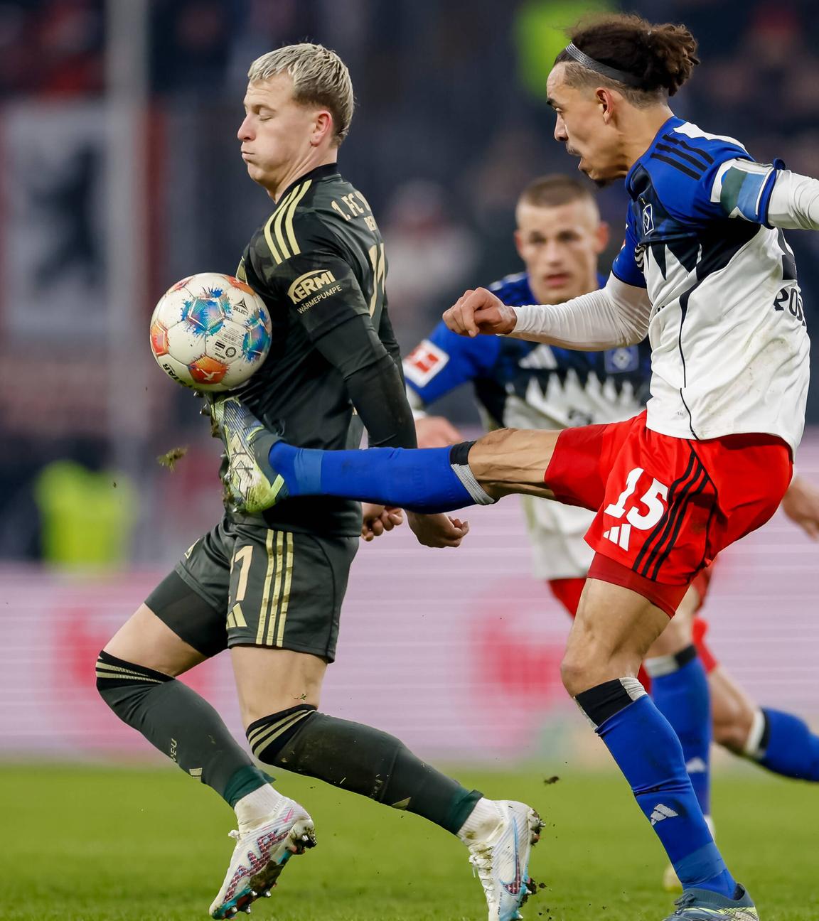 Hamburgs Stürmer Yussuf Poulsen versucht im Zweikampf mit Unions Stürker Tim Skarke den Ball mit ausgestrecktem Bein auf Hüfthöhe zu erreichen