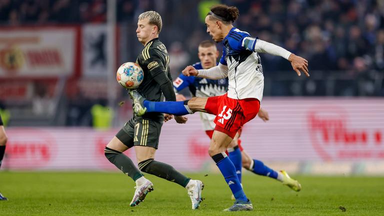 Hamburgs Stürmer Yussuf Poulsen versucht im Zweikampf mit Unions Stürker Tim Skarke den Ball mit ausgestrecktem Bein auf Hüfthöhe zu erreichen