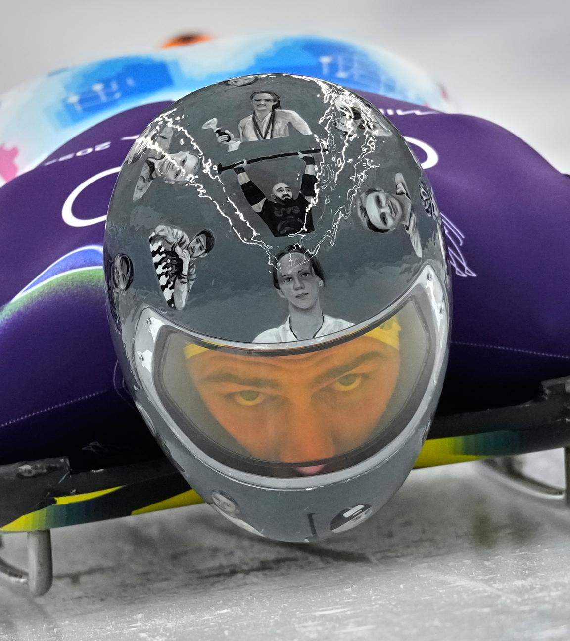 Der Skeleton-Pilot Wladyslaw Heraskewytsch ist frontal zu sehen. Er trägt einen Helm, der die verstorbenen ukrainischen Athleten abbildet.