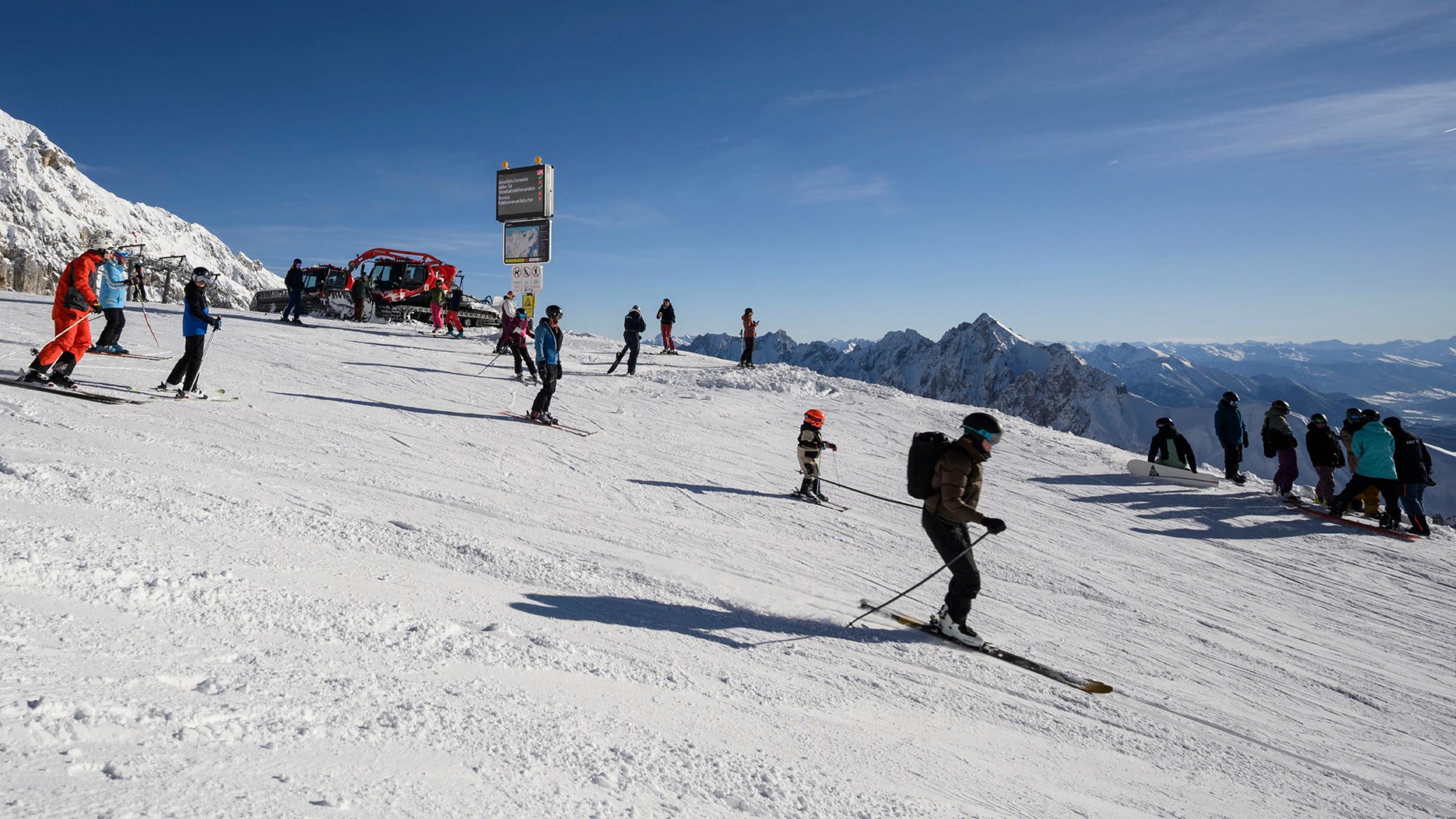 Skifahrer genießen Schnee und Sonne am ersten Skitag auf der Zugspitze (2962 m) nahe Grainau und Garmisch-Partenkirchen in Süddeutschland am 28. November 2025.