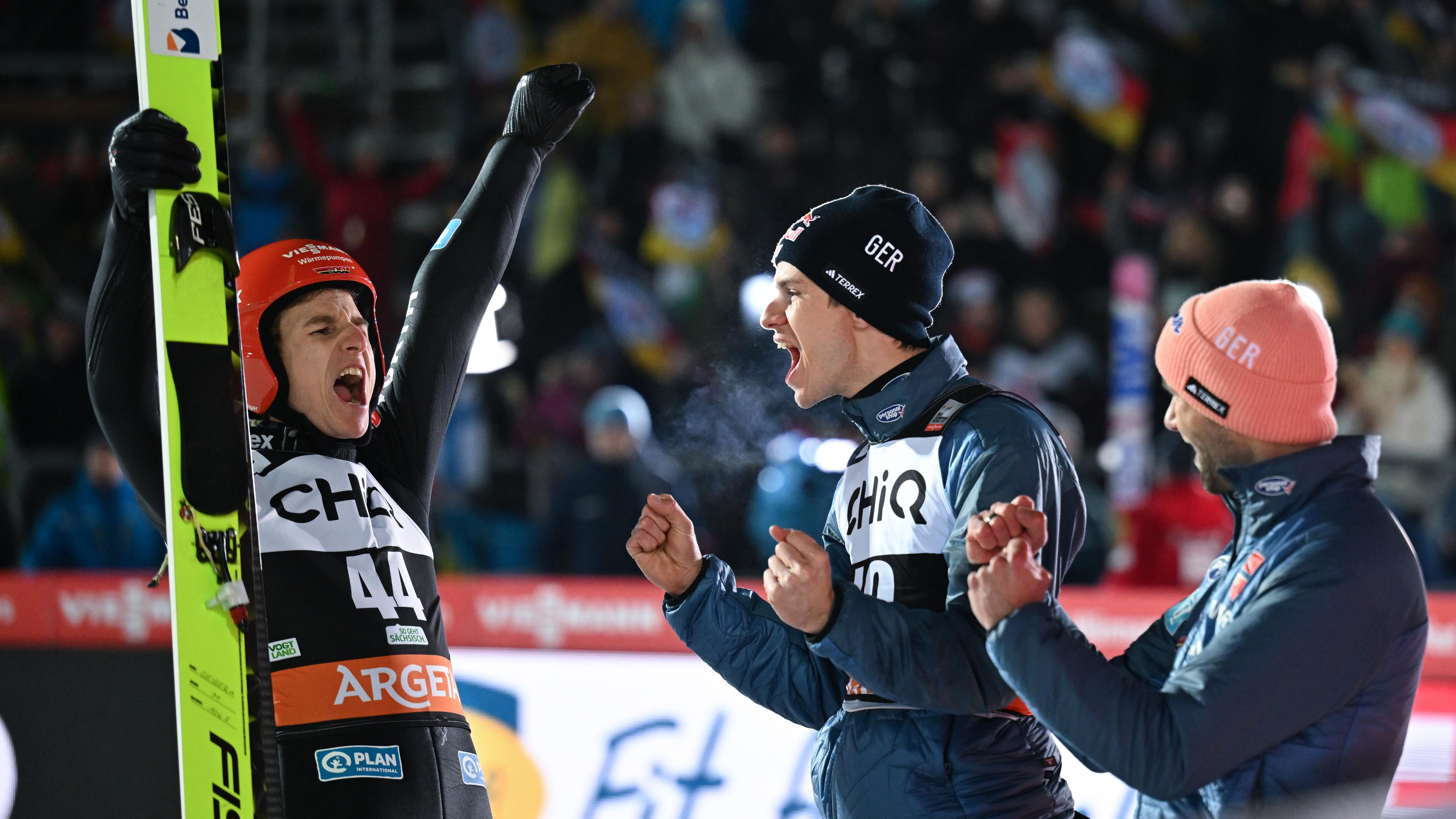 Karl Geiger (v.l.) aus Deutschland freut sich über seinen Sieg und jubelt mit Andreas Wellinger und Pius Paschke aus dem deutschen Team, aufgenommen am 09.12.2023