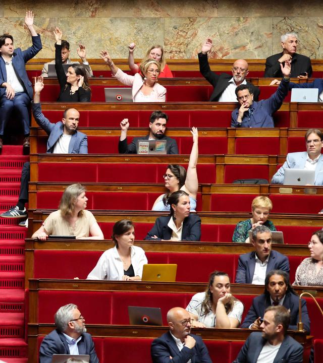 Parteimitglieder der France Insoumise heben ihre Hände im französischen Parlament bei einer Abstimmung zur Abschaffung des Sklavengesetzes.