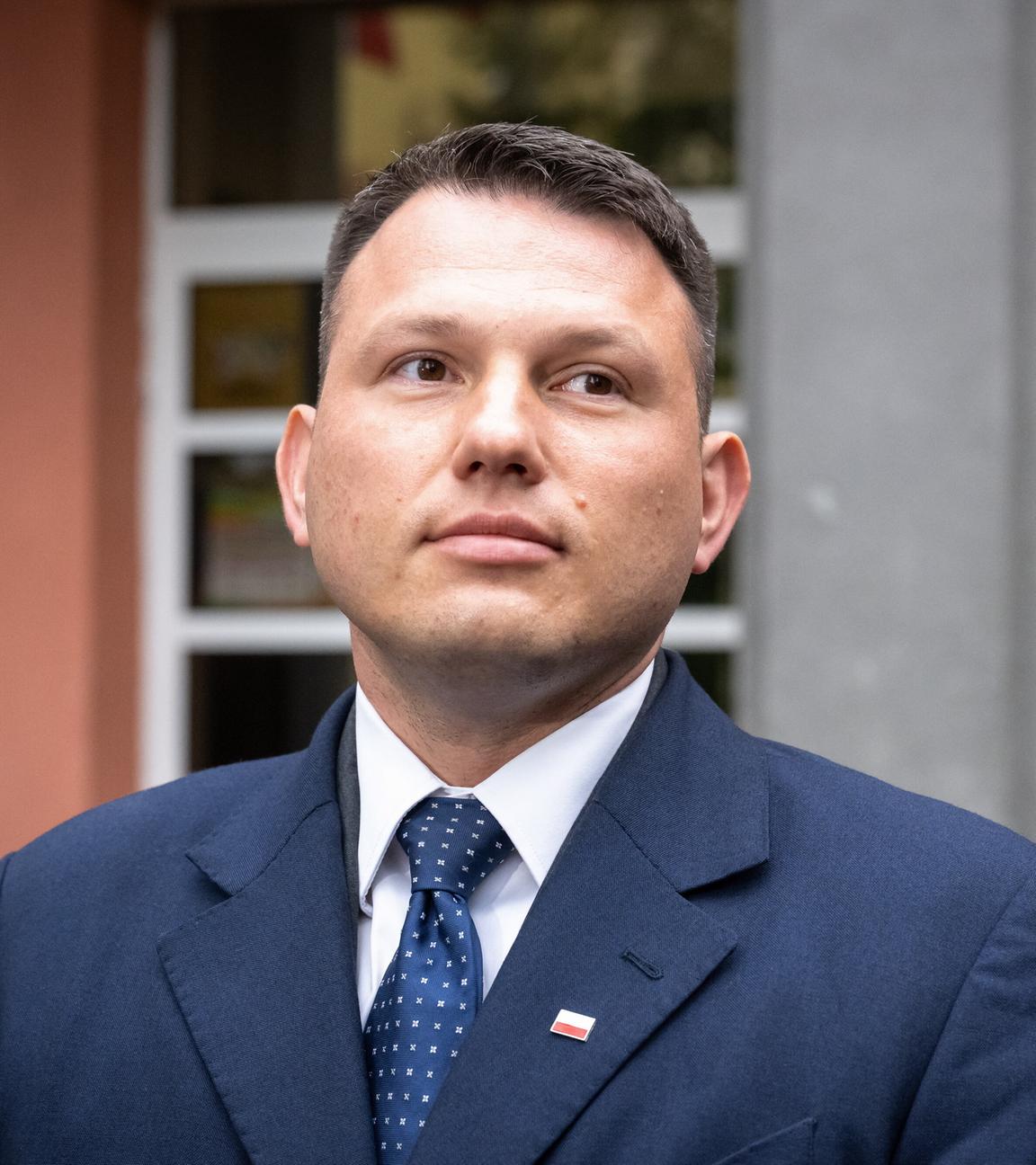 Sławomir Mentzen steht vor einem Wahllokal.