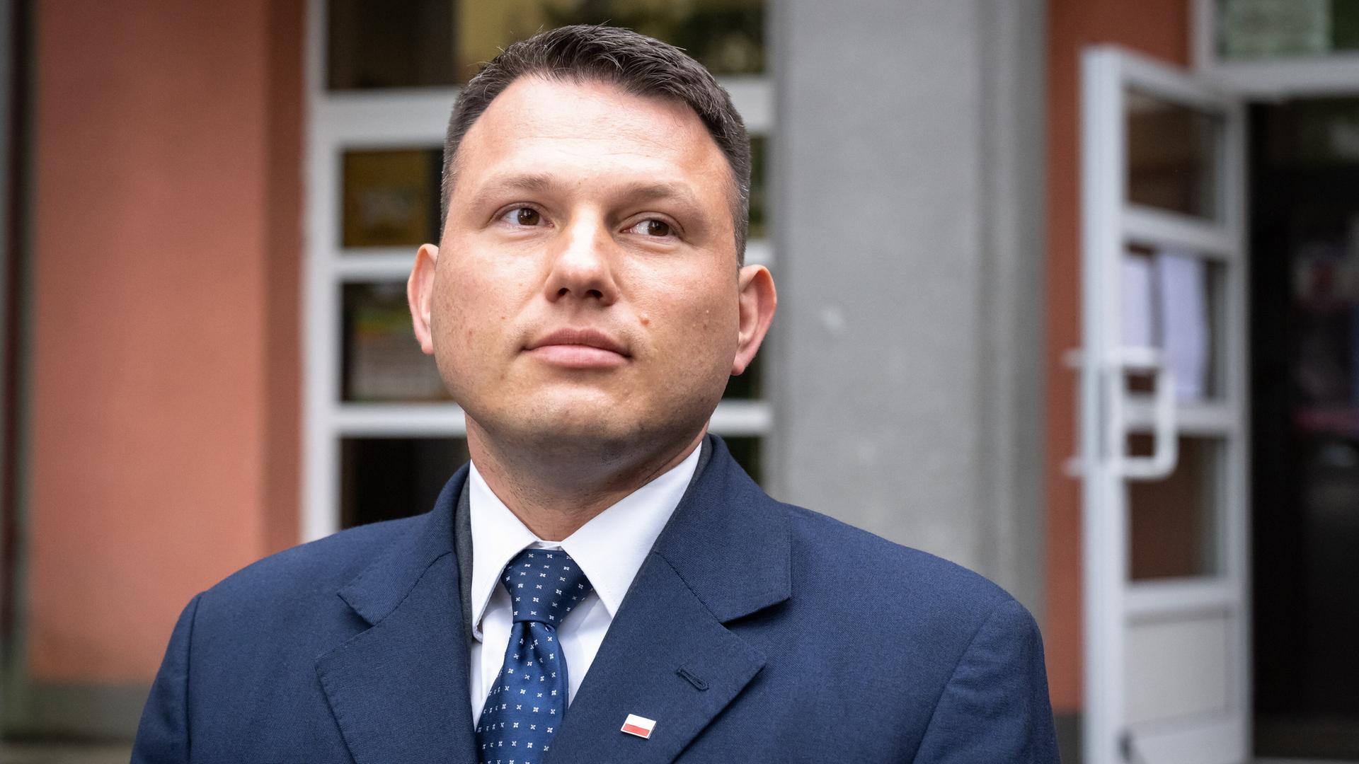 Sławomir Mentzen steht vor einem Wahllokal.