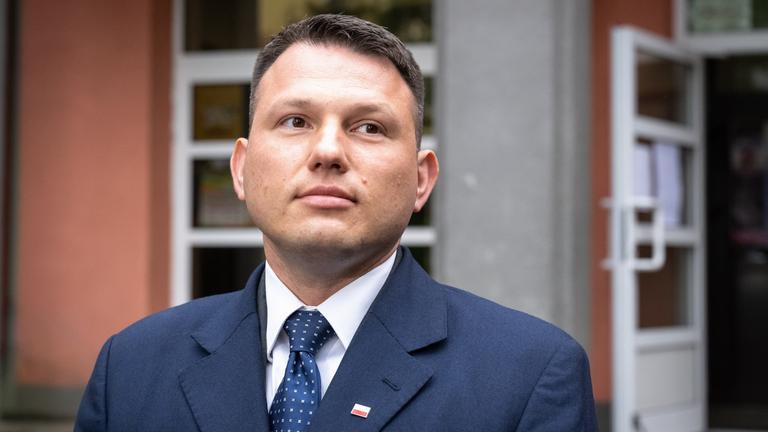 Sławomir Mentzen steht vor einem Wahllokal.