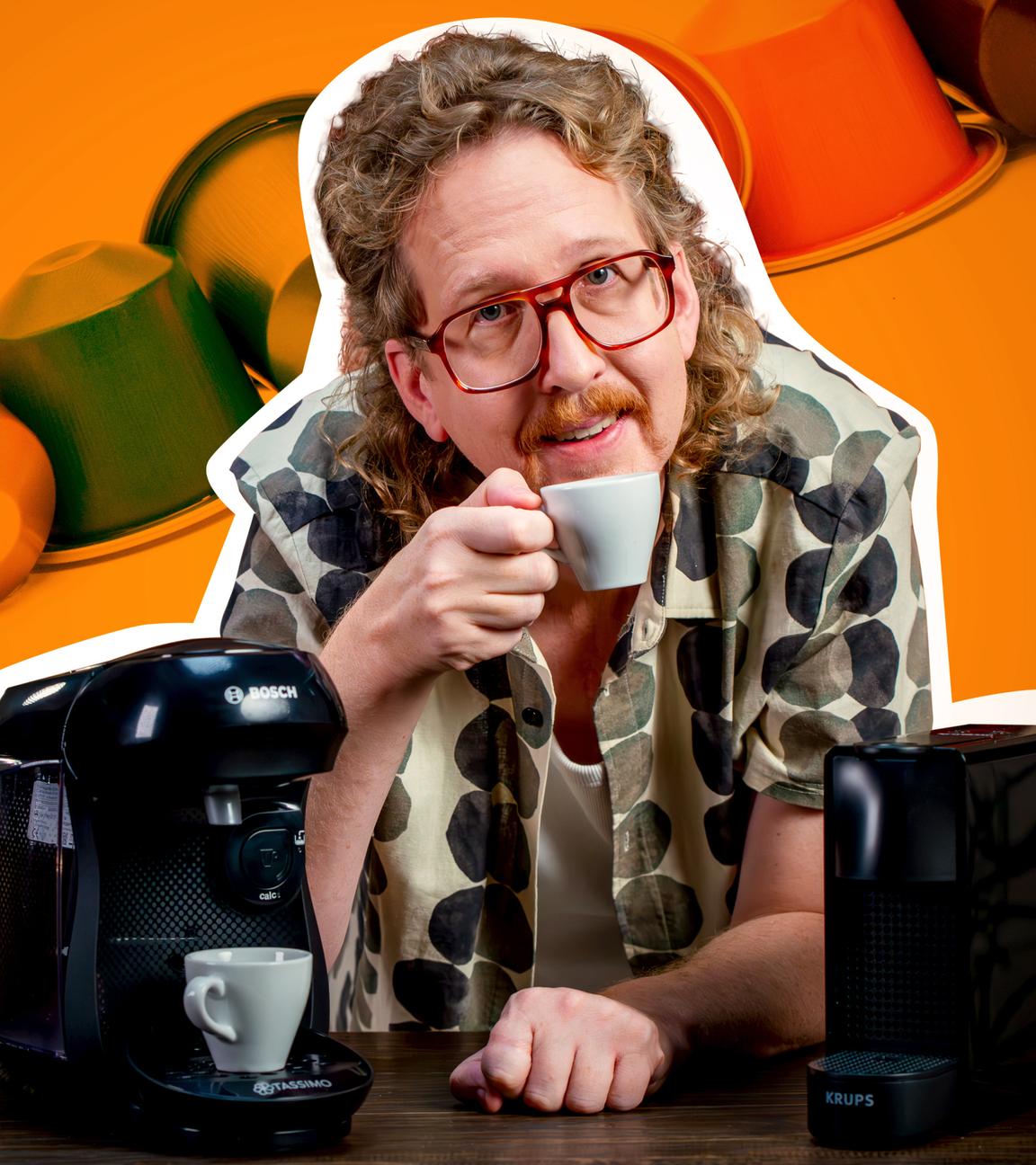 Montage: Uke Bosse steht zwischen den beiden Testgeräten, hält eine Kaffeetasse in der Hand und schaut in die Kamera. Im Hintergrund liegt eine Reihe Kaffeekapseln.