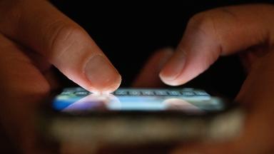 Sachsen, Dresden: Eine Frau tippt auf einem Smartphone.