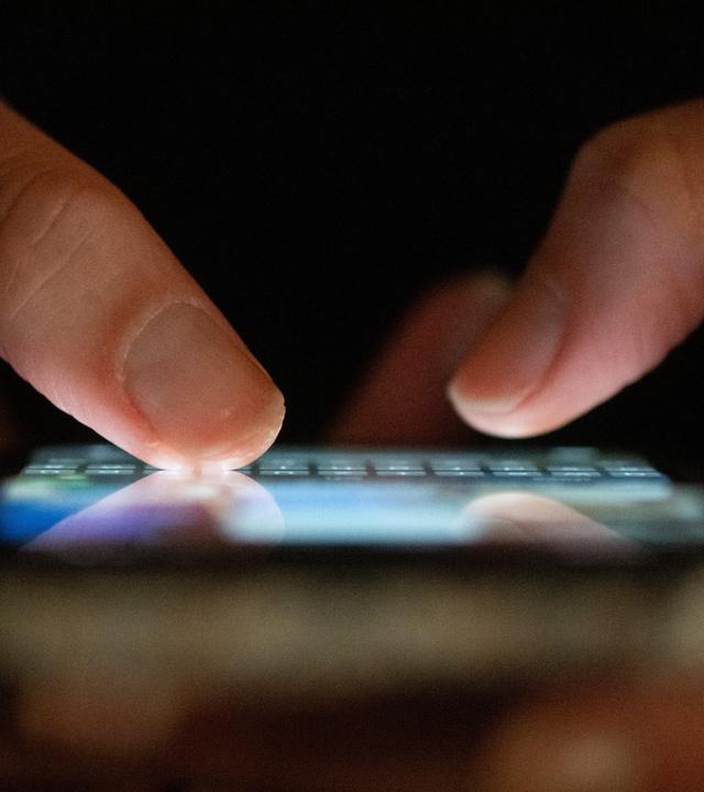 Sachsen, Dresden: Eine Frau tippt auf einem Smartphone.