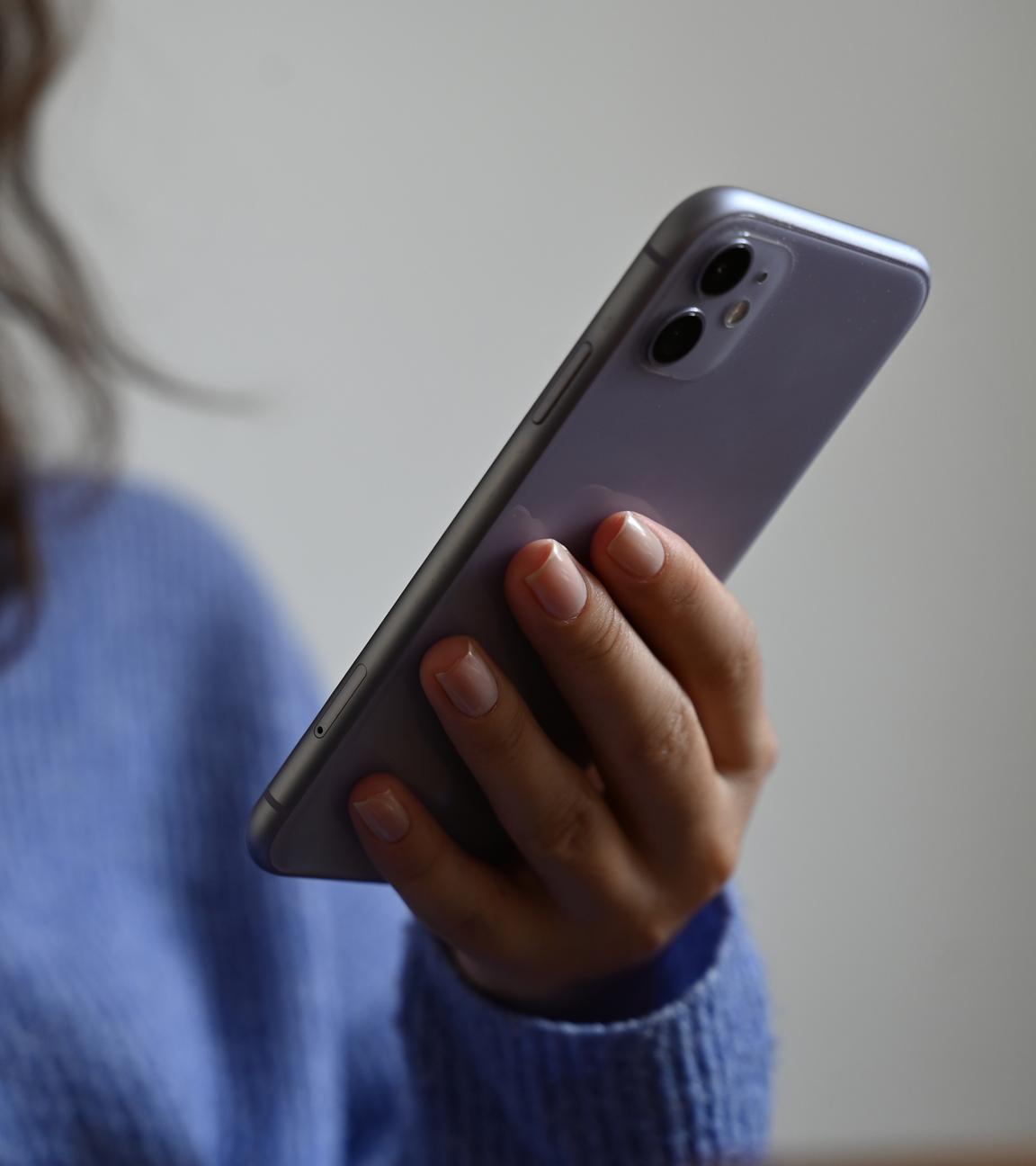 Berlin: Eine Frau hält ein Smartphone in der Hand.