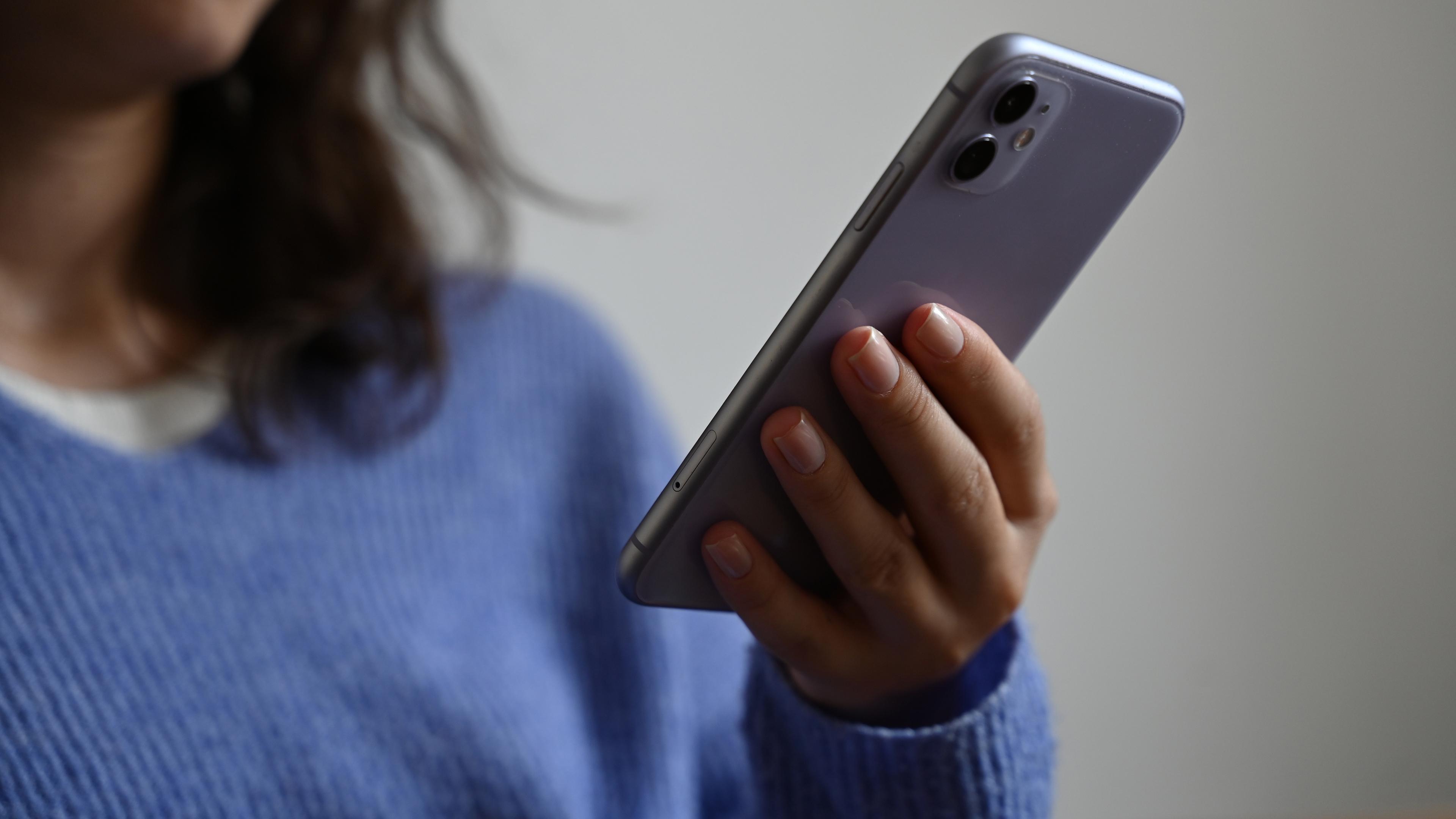 Berlin: Eine Frau hält ein Smartphone in der Hand.