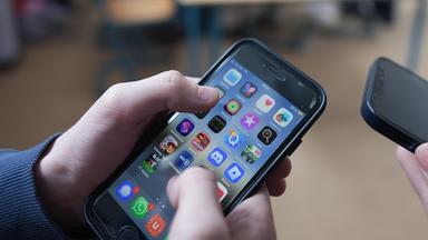 13.02.2026, Hamburg: Zwei Schüler stehen in einem Klassenraum im Goethe-Gymnasium und schauen auf ihre Smartphones. Aktuell wird in Deutschland über Altersgrenzen für soziale Medien sowie über mögliche strengere Regeln zur Handynutzung an Schulen diskutiert.