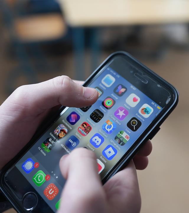 13.02.2026, Hamburg: Zwei Schüler stehen in einem Klassenraum im Goethe-Gymnasium und schauen auf ihre Smartphones. Aktuell wird in Deutschland über Altersgrenzen für soziale Medien sowie über mögliche strengere Regeln zur Handynutzung an Schulen diskutiert.