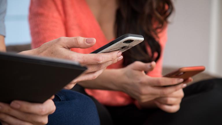 Junge Menschen halten Smartphones in den Händen.
