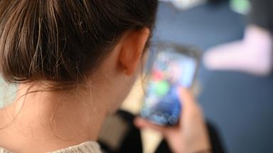 Eine Frau öffnet auf ihrem Smartphone einen Ordner mit Apps verschiedener sozialer Medien (Archivfoto)