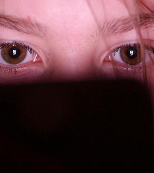 Symbolbild: Ein Mädchen schaut auf einem Smartphone ein Make-up-Tutorial auf einer Social-Media-Plattform. 