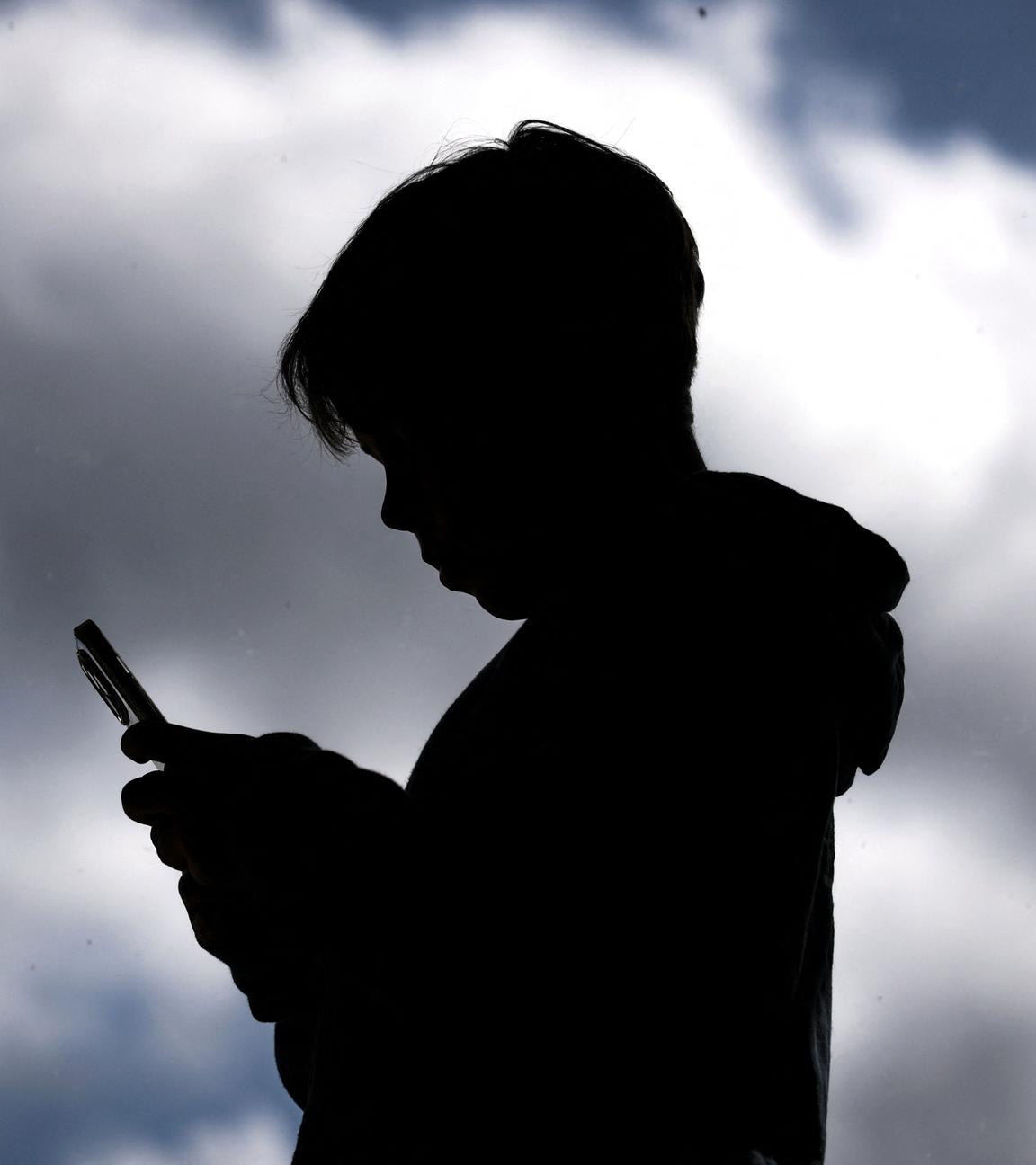 Ein kleiner Junge schaut auf ein Smartphone