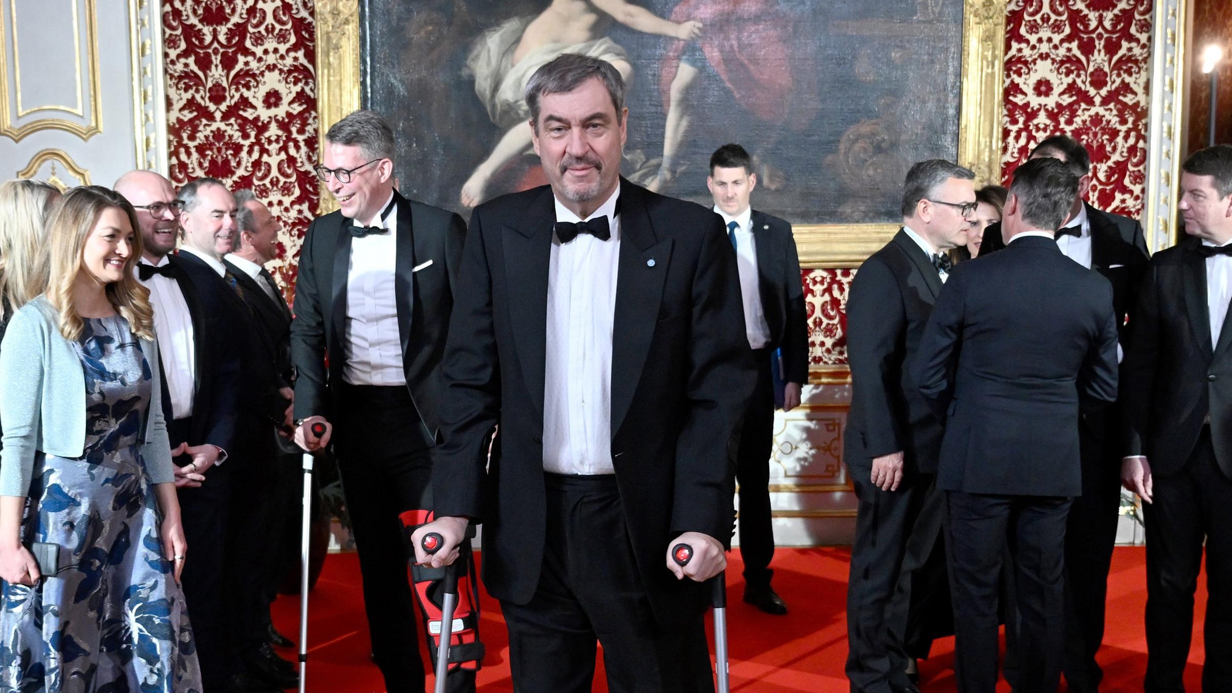 Ministerpräsident Bayerns Markus Söder kommt auf Krücken zum Neujahrsempfang in der Müncher Residenz.