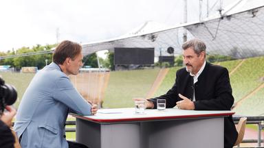 Wulf Schmiese und Markus Söder sitzen sich gegenüber und sind im Gespräch