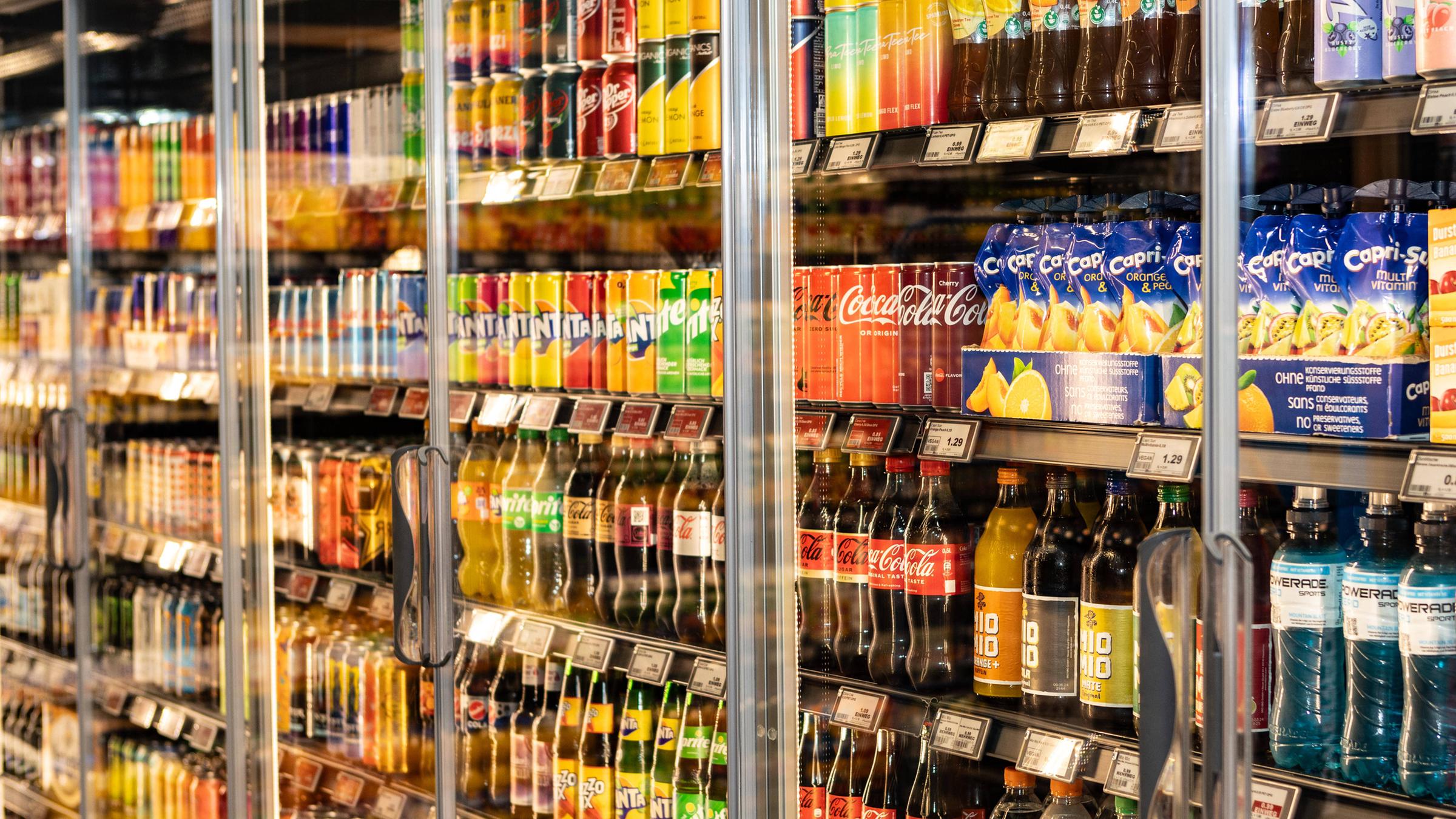 Ein Kühlregal mit unterschiedlichen Softdrinks, darunter, Capri-Sonne, Coca Cola, Fanta, Sprite, Mezo-Mix und Vitrex. 