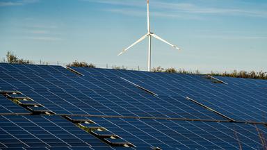 10.11.2022, Rheinland-Pfalz, Freimersheim: Ein Windrad steht auf einem Hügel oberhalb einer großflächigen Solaranlage auf einem Feld im Landkreis Alzey-Worms. Klimaneutral erzeugter Strom hat 2023 erstmals mehr als die Hälfte des Stromverbrauchs in Deutschland gedeckt.