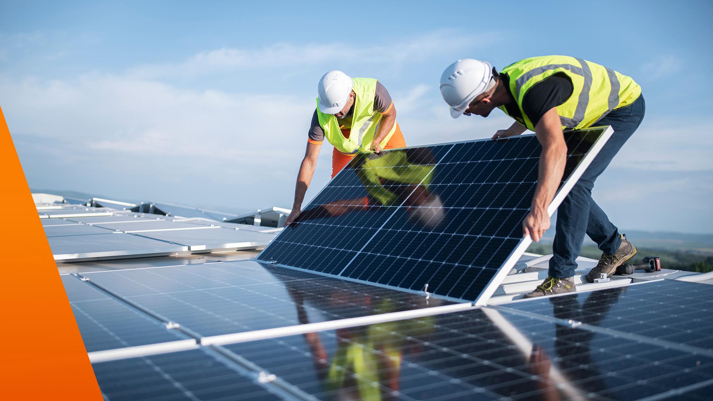 Zwei Männer bringen eine Solaranlage auf dem Dach an