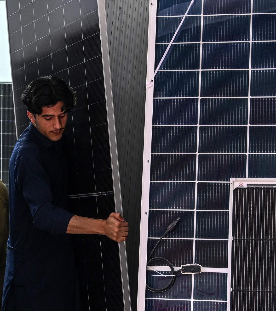 Ein Arbeiter stellt am 04.04.2026 in einem Elektrofachgeschäft in Rawalpindi Solarmodule auf, während Pakistan angesichts des Krieges im Nahen Osten mit Störungen in der Energieversorgungskette konfrontiert ist. 