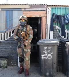 In Kapstadt kommt ein schwer bewaffneter Soldat aus einer Unterkunft in den Cape Flats