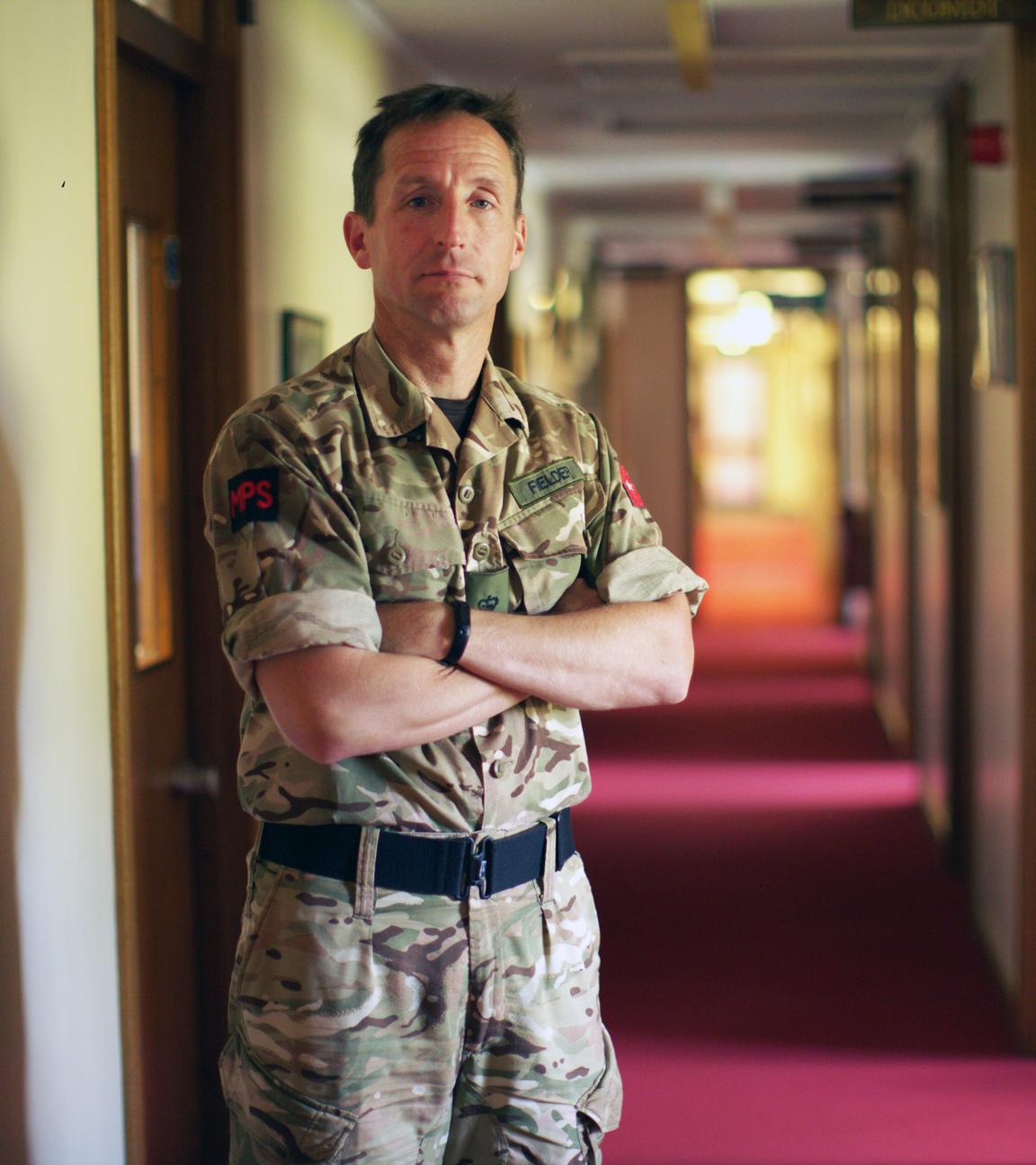 Lieutenant Colonel Mike in Camouflage-Anzug mit verschränkten Armen.