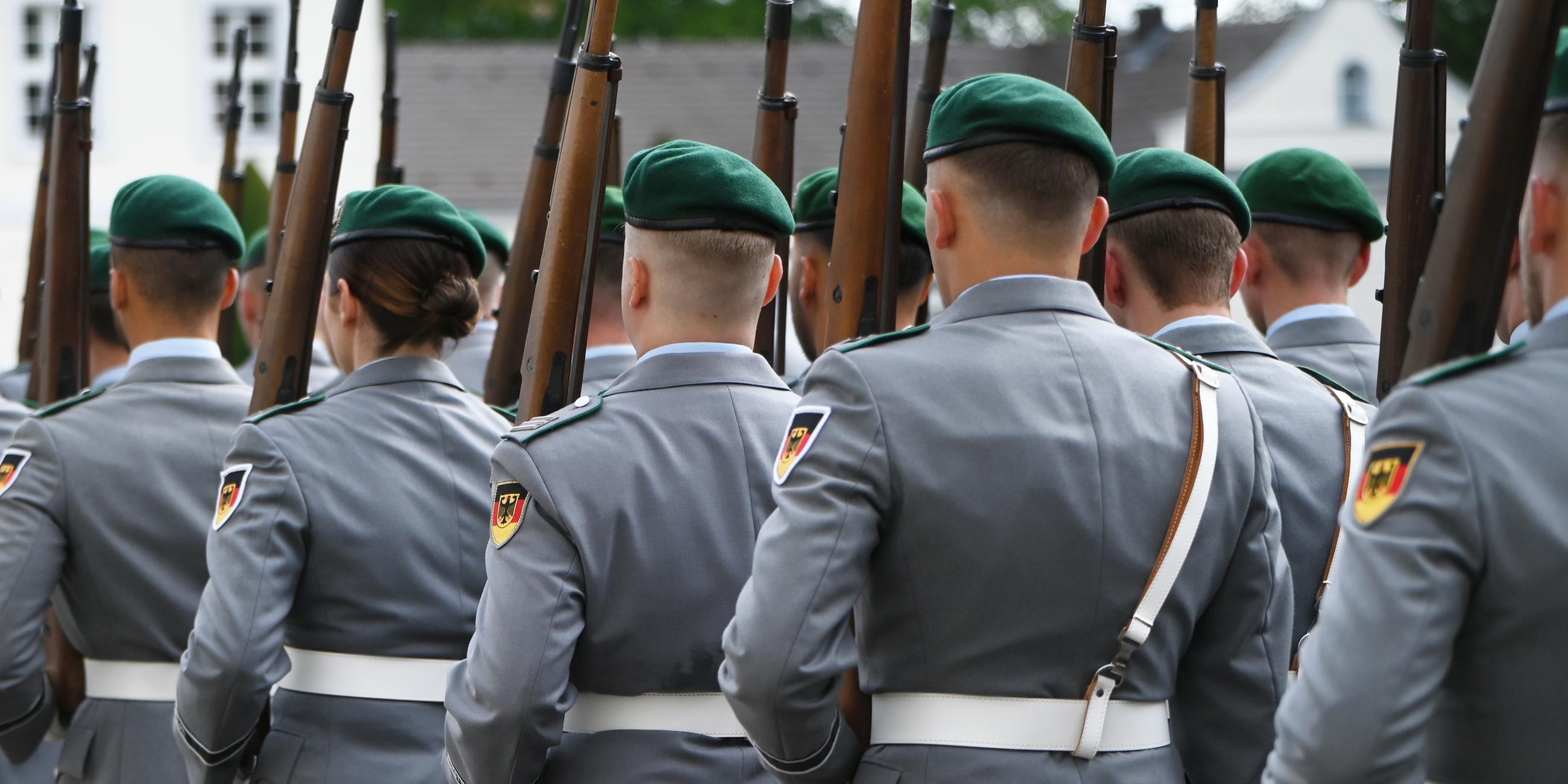 Soldatinnen und Soldaten der Bundeswehr marschieren bei einer militärischen Zeremonie vor dem Schloss Bellevue in Berlin.