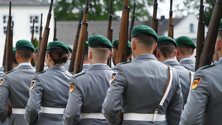 Soldatinnen und Soldaten der Bundeswehr marschieren bei einer militärischen Zeremonie vor dem Schloss Bellevue in Berlin.