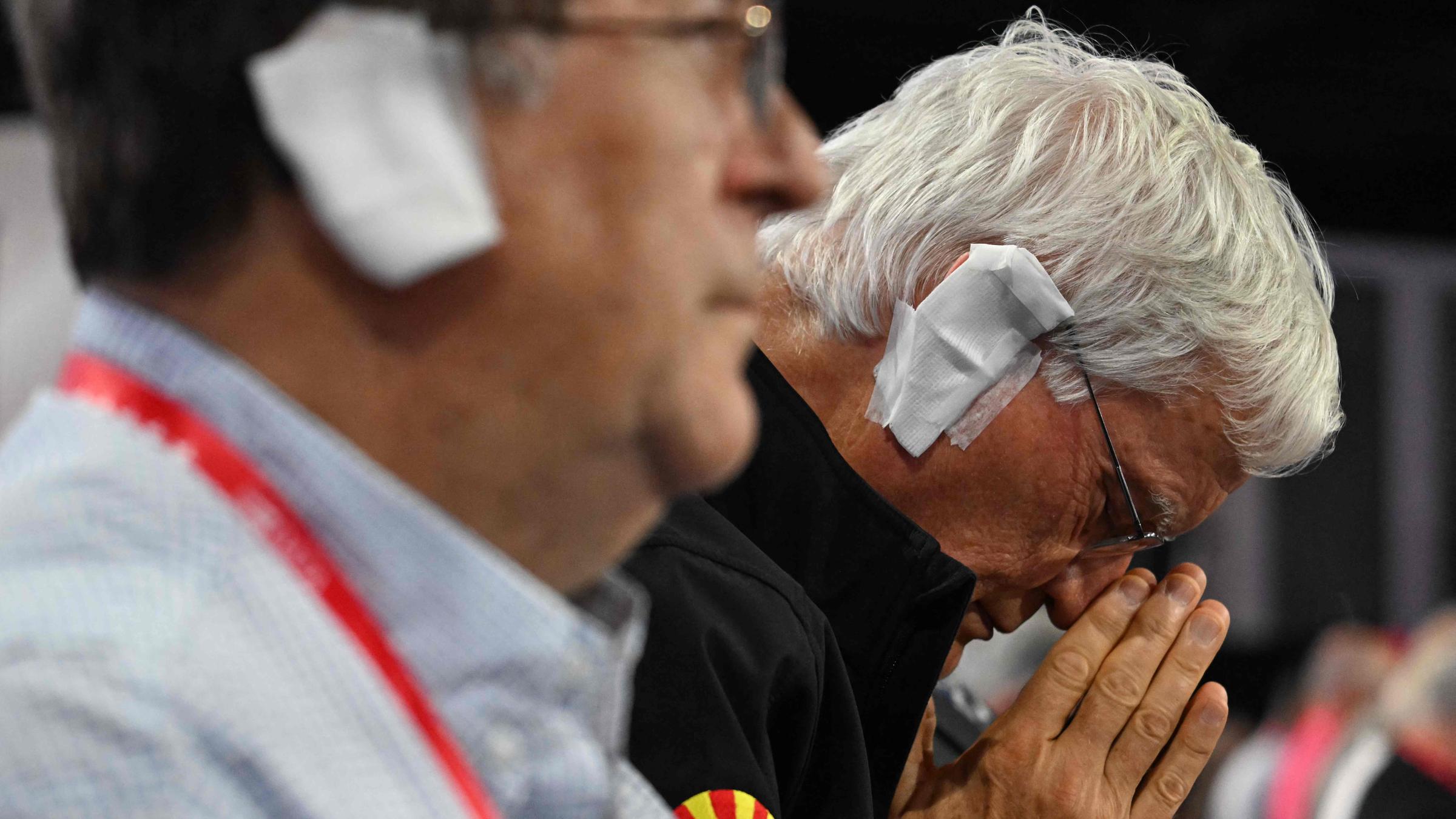 Teilnehmer tragen ein Pflaster über dem Ohr aus Solidarität mit Donald Trump am 17.07.2024.