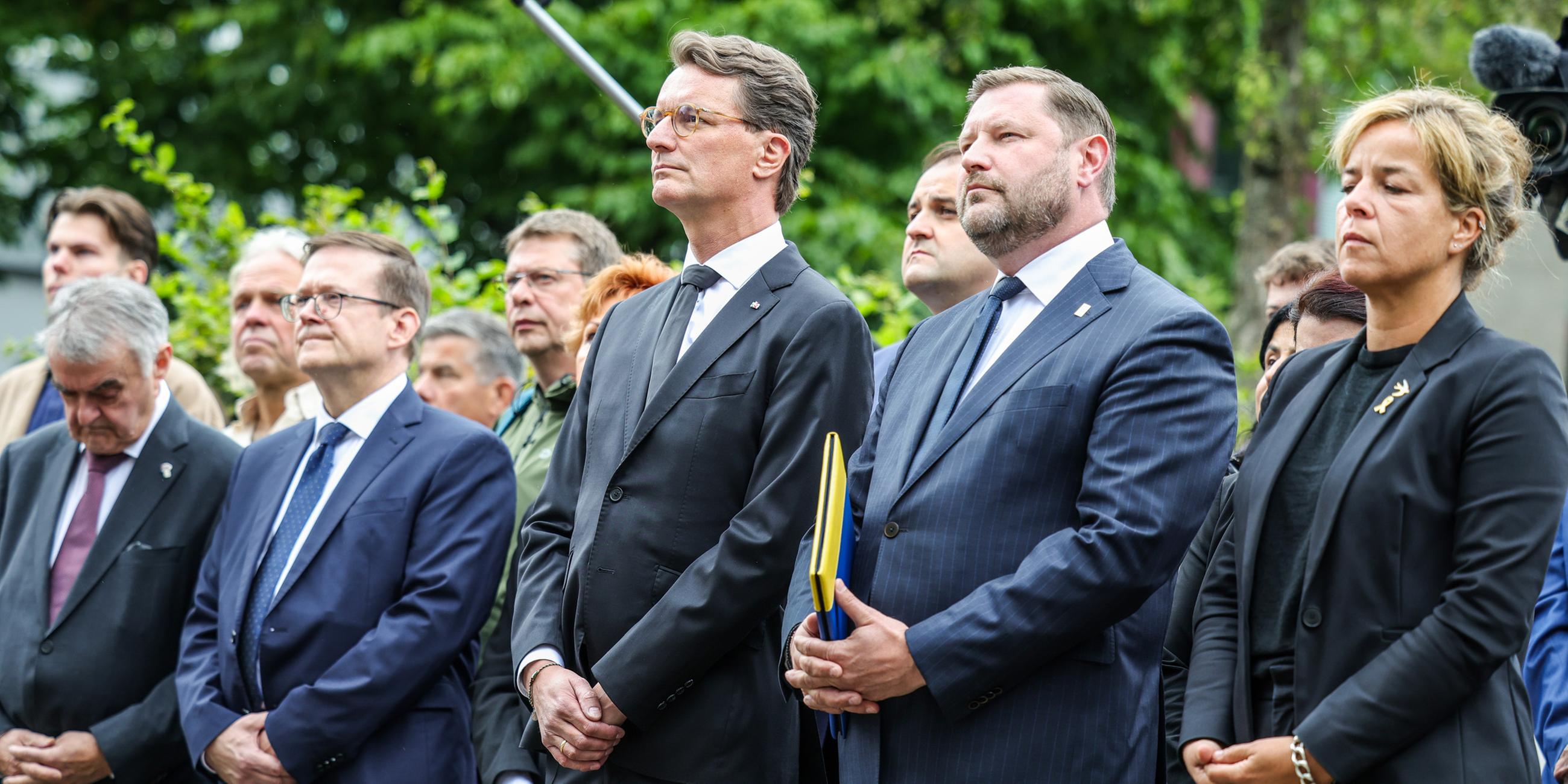 Herbert Reul (CDU, l), Innenminister von Nordrhein-Westfalen, Hendrik Wüst (3.v.r, CDU), Ministerpräsident von Nordrhein-Westfalen, Tim Kurzbach (2.v.r), Oberbürgermeister der Stadt Solingen und Mona Neubaur (r, Bündnis 90/Grüne), Ministerin für Wirtschaft, Industrie, Klimaschutz und Energie von Nordrhein-Westfalen, stehen zusammen bei der Gedenfeier in Solingen.