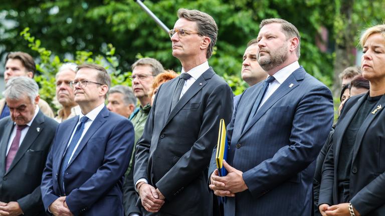 Herbert Reul (CDU, l), Innenminister von Nordrhein-Westfalen, Hendrik Wüst (3.v.r, CDU), Ministerpräsident von Nordrhein-Westfalen, Tim Kurzbach (2.v.r), Oberbürgermeister der Stadt Solingen und Mona Neubaur (r, Bündnis 90/Grüne), Ministerin für Wirtschaft, Industrie, Klimaschutz und Energie von Nordrhein-Westfalen, stehen zusammen bei der Gedenfeier in Solingen.