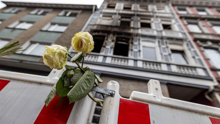Eine weiße Rose an einer Absperrbake vor dem Brandort in Solingen.