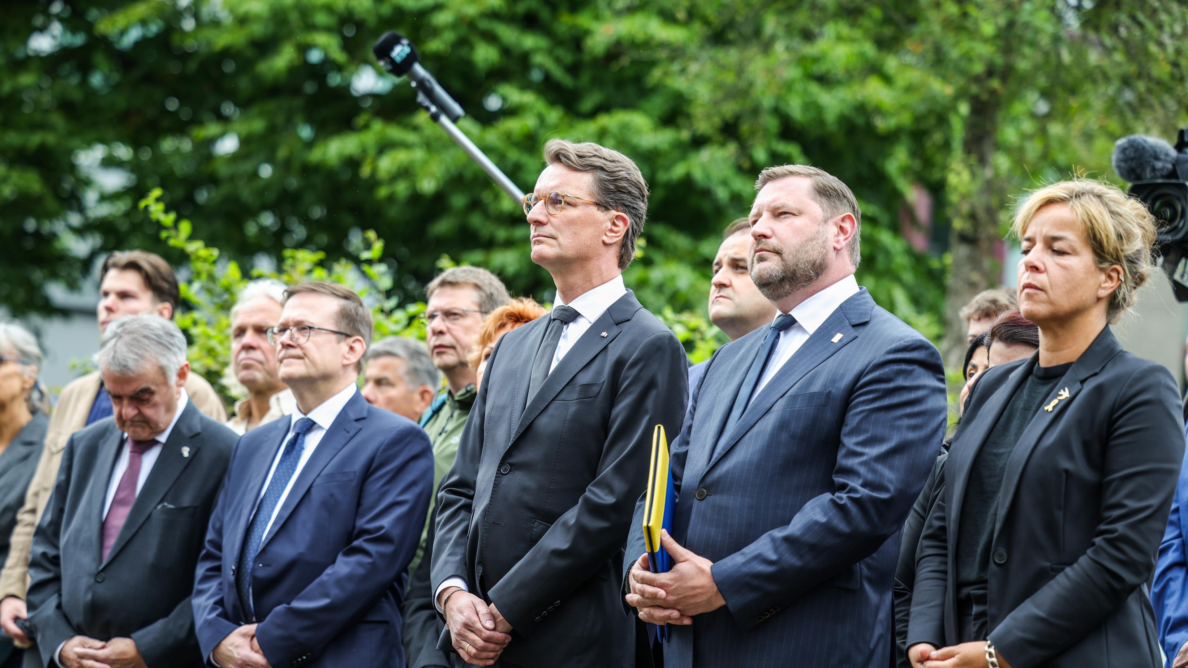 Nordrhein-Westfalen, Solingen: Herbert Reul (CDU, l), Innenminister von Nordrhein-Westfalen, Hendrik Wüst (3.v.r, CDU), Ministerpräsident von Nordrhein-Westfalen, Tim Kurzbach (2.v.r), Oberbürgermeister der Stadt Solingen und Mona Neubaur (r, Bündnis 90/Grüne), Ministerin für Wirtschaft, Industrie, Klimaschutz und Energie von Nordrhein-Westfalen, stehen zusammen bei der Gedenfeier in Solingen.