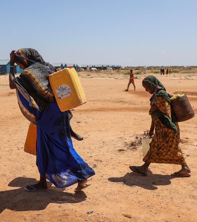 Eine Frau und ihre Kinder tragen Wasserkanister im Flüchtlingslager Ladan bei Dollow in Somalia.