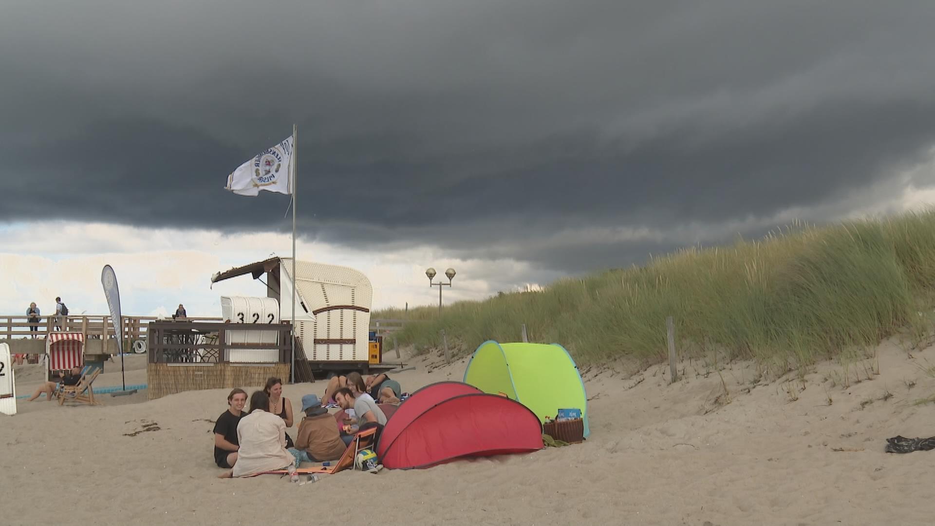 Touristen am Strand bei schlechtem Wetter