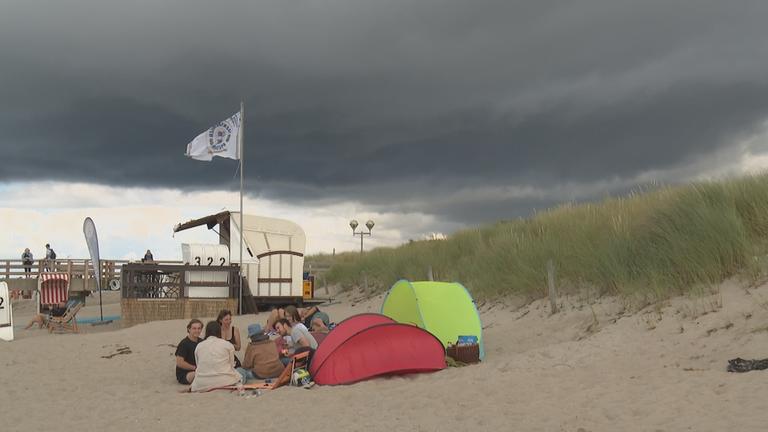 Touristen am Strand bei schlechtem Wetter