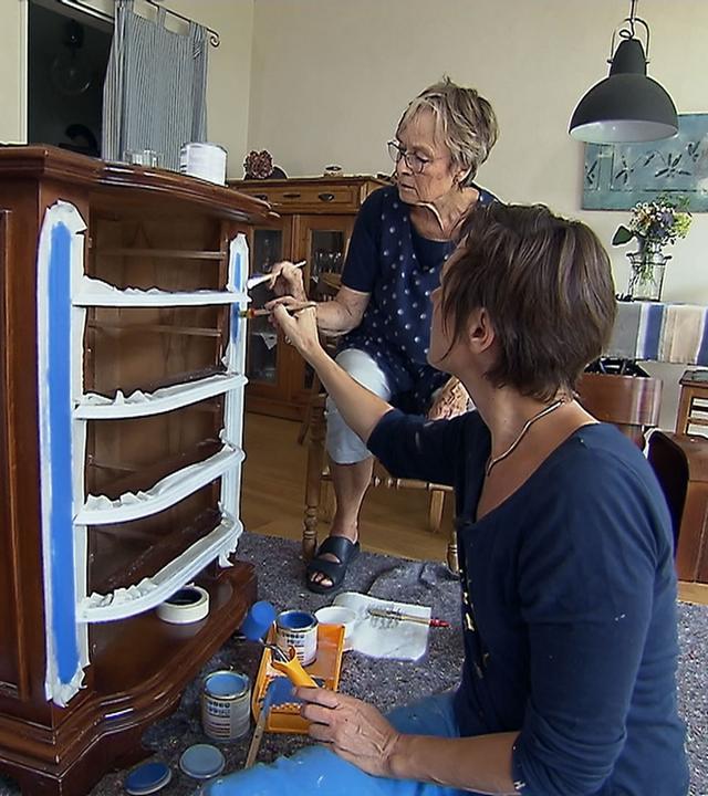 Ulrike Eichel-Selbach und Einrichtungsexpertin Ann-Kathrin Otto streichen eine Holzkommode.