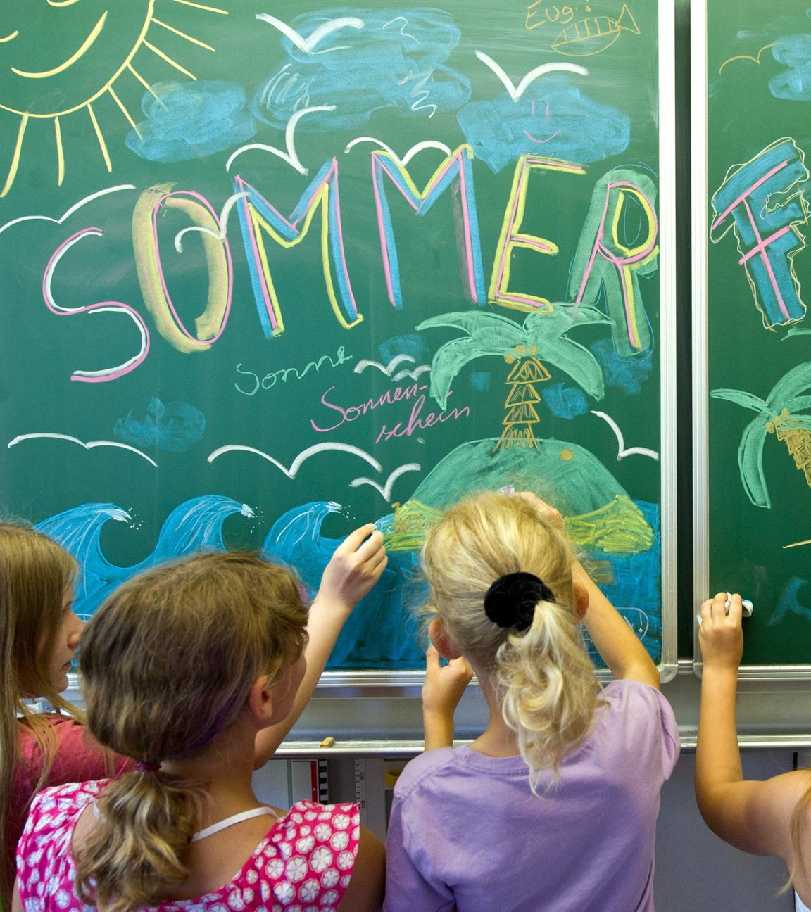 Schülerinnen einer 5. Klasse der Evangelischen Grundschule in Frankfurt (Oder) gestalten vor der Zeugnisausgabe und dem Beginn der Sommerferien eine Schultafel in ihrem Klassenraum.