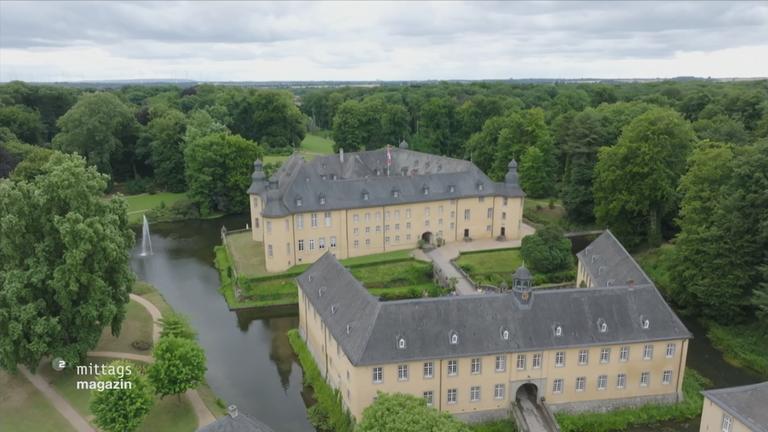 Reporterin Sabine Platz steht in einem Schlossgarten
