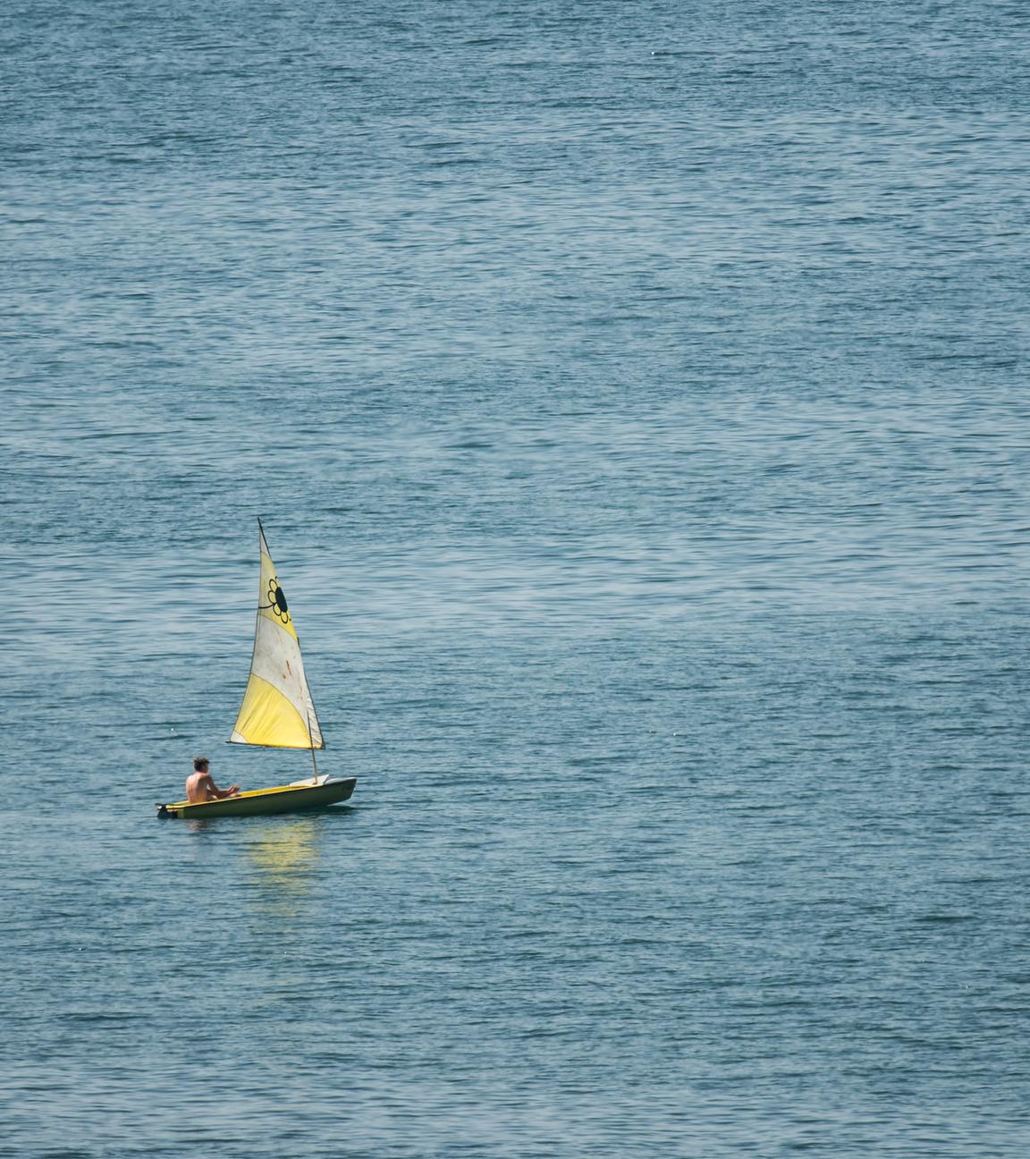 Baden-Württemberg, Überlingen: Ein Mann segelt mit einem kleinen Segelboot auf dem Bodensee bei Überlingen. Nach der Hitze werden am Wochenende teilweise Gewitter und Starkregen erwartet.