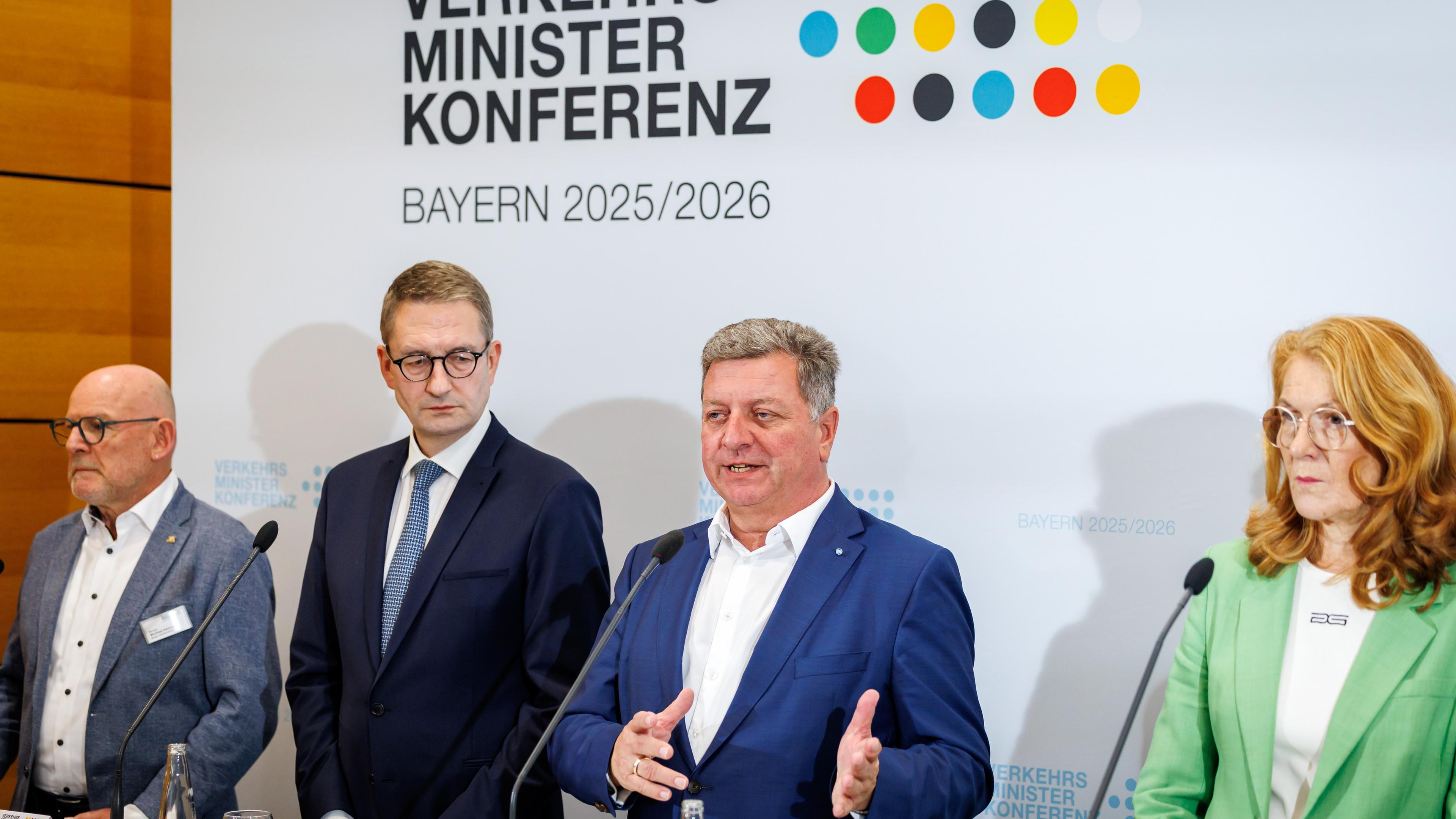 Pressekonfernz der Verkehrsminister. Vier Minister stehen an einem Rednerpult. Im Hintergund ist eine weiße Wand mit der Aufschrift Verkehrsministerkonferenz und bunten Punkten