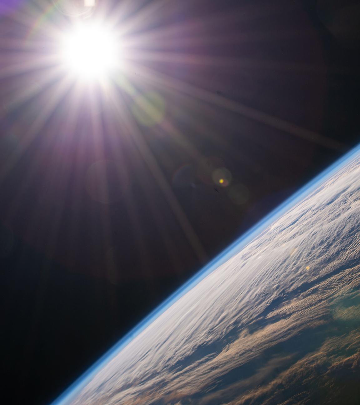 30.12.2021, ---, ISS: Die Sonne scheint über dem Horizont der Erde, während die Internationale Raumstation über der kanadischen Provinz Quebec kreist. 