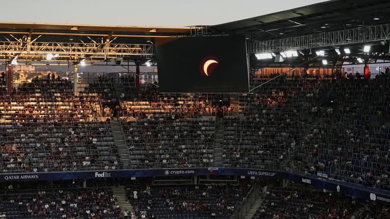 Vor dem UEFA-Supercup-Fußballspiel zwischen Paris Saint-Germain und Aston Villa wird auf einer Stadionleinwand ein Live-Video der Sonnenfinsternis gezeigt.