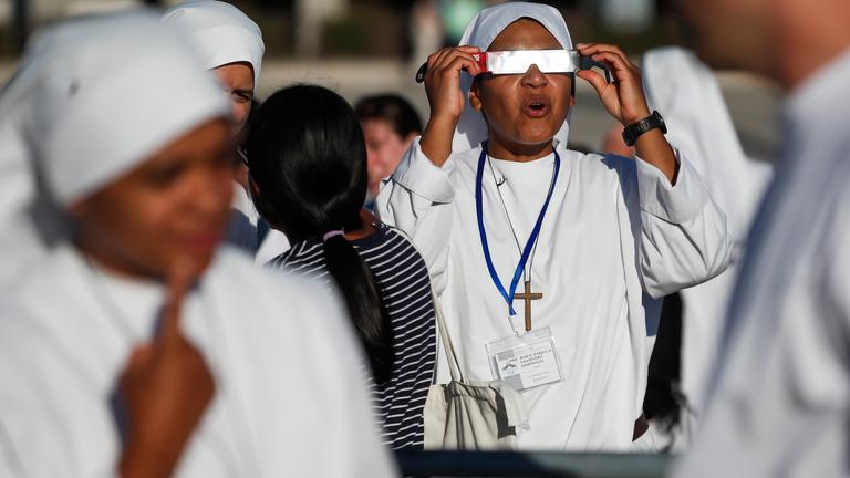 Nonnen mit Schutzbrillen beobachten die Sonnenfinsternis in Portugal.