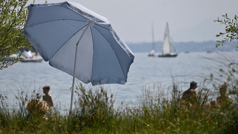 Ein Sonnenschirm steht am Ufer des Starnberger Sees