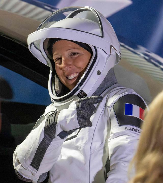 Die ESA-Astronautin Sophie Adenot deutet auf die französische Flagge an ihrer Schulter, während sie sich am 13. Februar 2026 auf der Cape Canaveral Space Force Station in Florida auf den Weg zur SpaceX-Rakete Falcon 9 und dem dazugehörigen Dragon-Raumschiff am Startkomplex 40 für die Mission Crew-12 macht.